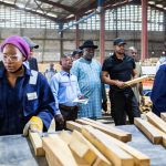 Chief Amechi watching the workers of Woodland factory work